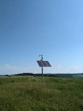 Remote mast with weather sensor webcam and wifi powered by solar panel in open 库存照片