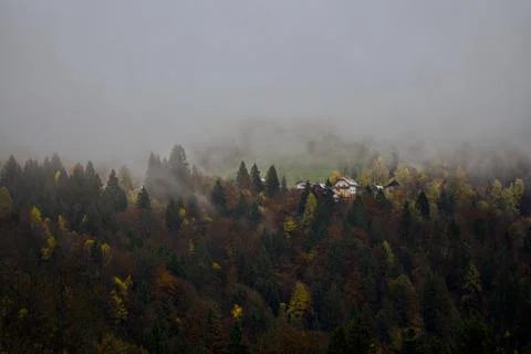 Remote mountain cabin enveloped in mist with scenic views Stock Photos