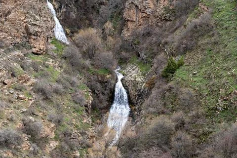 Remote mountain gorge with double waterfall and rocky terrain. Stock-Fotos