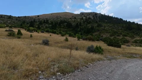 Remote mountain landscape with rough road dry grassland and cloudy weather Video stock 327560506