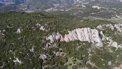Remote mountain road through barren rocky landscape near fertile valley horizon Stock Footage 344095577