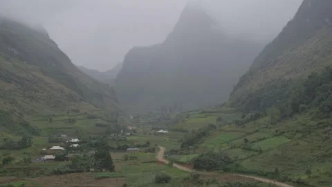Remote Mountain Valley With Winding Road And Misty Limestone Peaks Stock Footage 336719375