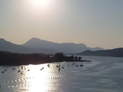 Remote Rocky Beach and Turquoise Bay at Sunset Stock Photos
