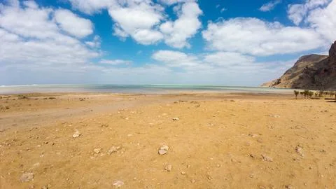 Remote sandy coast with mountain and cloudy sky. Socotra, Yemen. Stockfoto's