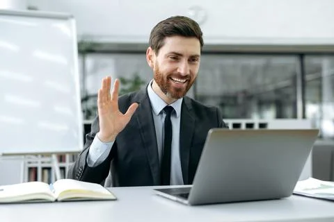 Remote video communication. Friendly successful caucasian businessman sitting in Stock Photos