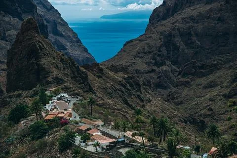 Remote village nestled between dramatic cliffs with ocean view Stock Photos