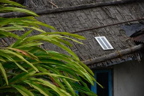 A remote village thatch house using solar panel Stock Photos