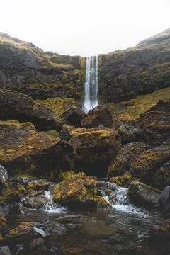 Remote waterfall drops through mossy basalt cliffs in West Iceland 스톡 사진