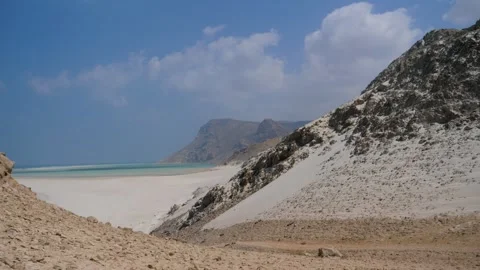 Remote white sand beach between rocky cliffs and turquoise sea, Socotra island Stock Footage 336982366