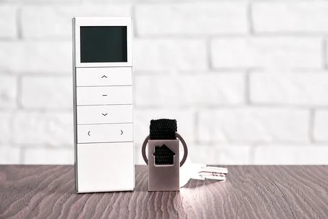 Remote wireless digital security controller and door keys on the table Stock Photos
