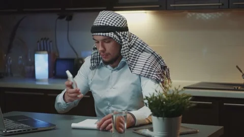 Remote work: Arab businessman receiving customer's call and discussing something Stock Footage 157598892
