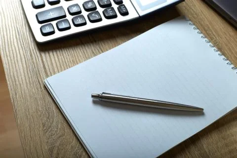 Remote work calculator notepad with pen on the table Stock Photos