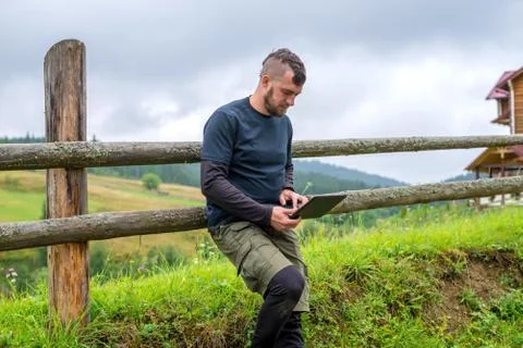 Remote work concept: a man working on a laptop outdoors. Stock Photos