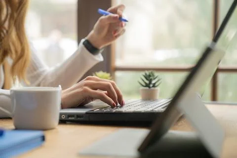 Remote Work Concept, Woman Taking Notes While Using Laptop at Home Office 스톡 사진