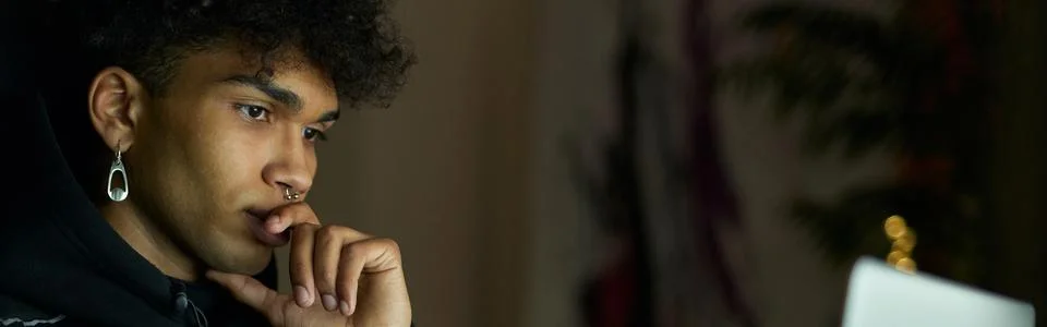 Remote work. Focused young guy with piercing sitting in front of laptop screen 스톡 사진