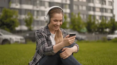 Remote work. girl communicates with a client while sitting in a park. 4K Stock Footage 127625646