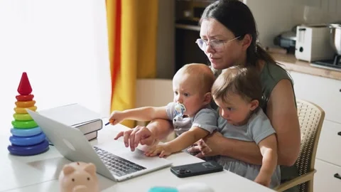Remote work at home at table with laptop. upbringing of toddlers. Mom with Video stock 255238676