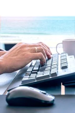 Remote work on keyboard with ocean view Stock Photos
