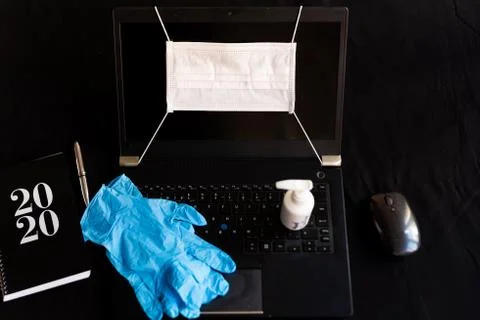 Remote work kit on black background home office desk with hand sanitizer and Fotos Stock