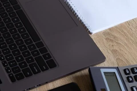 Remote work laptop calculator notepad and phone on the table Stock Photos