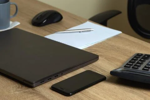 Remote work laptop calculator notepad with pen and phone on the table near ch Foto stock