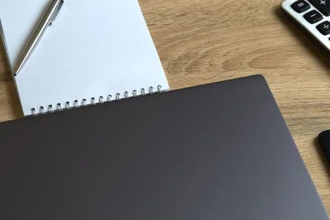 Remote work laptop calculator notepad with pen on the table Stock Photos