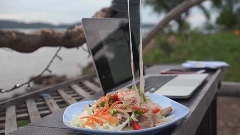 Remote Work Lunch: Enjoying Thai Salad by the Sea with Laptop Video stock 310324025
