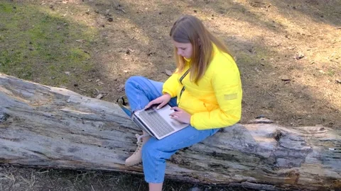 Remote work or study. View of the woman using a laptop sitting in the woods on a 스톡 동영상 165519927