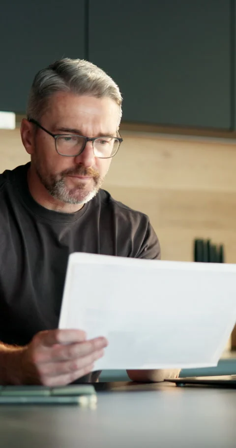 Remote work, paperwork and man with laptop in kitchen, risk assessment and Stock Footage 337149833