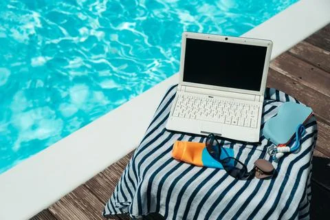 Remote Work by the Pool with Laptop and Sunscreen Stock Photos