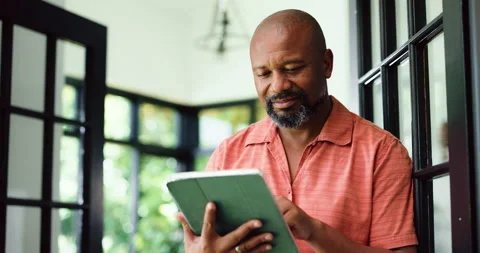 Remote work, reading or black man with tablet in home, proofreading or review Video stock 323279632