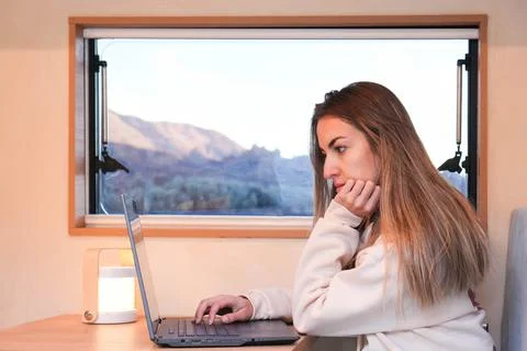 Remote Work on the Road: Digital Nomad Using Laptop in a Van at Dusk Stockfoto's