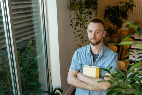 Remote work setup with an individual holding a notebook in a bright indoor .. Stock Photos