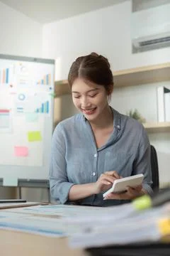 Remote Work. Woman taking notes while working in home office. Stock Photos