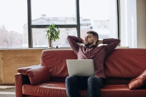 Remote work. Young man working at computer at home Stock Photos