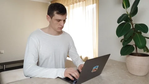 Remote work. Young serious man is typing something on a laptop 動画素材 126789530