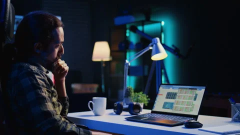 Remote worker comparing business graphic economic figures Stock Footage 263857948