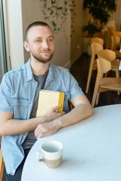 Remote worker engages in online learning while seated in a bright cafe with.. Stock Photos
