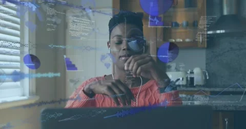 Remote worker gesturing and typing at laptop in kitchen, moving animated data Stock Footage 331005854