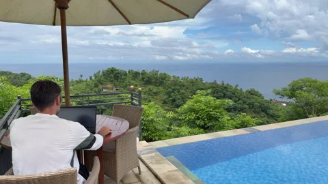 Remote worker laptop user working by infinity pool with view Stock Footage 336001823