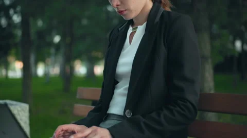 Remote Worker on Park Bench Focused on Laptop Amidst Greenery and Trees Vídeo Stock 305654451