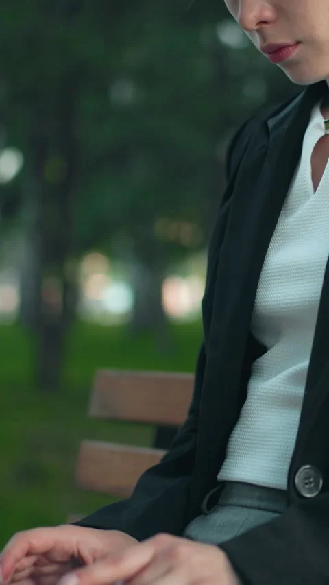 Remote Worker on Park Bench Focused on Laptop Amidst Greenery and Trees Vídeo Stock 319784961