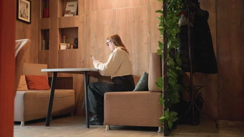 Remote worker responding to client with cushion in front and leaves behind Stock Footage 310754202