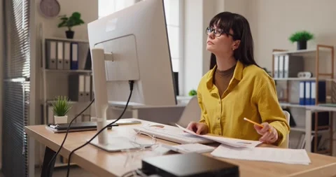 Remote worker reviewing documents at desktop computer in stylish home office Stock Footage 336006954
