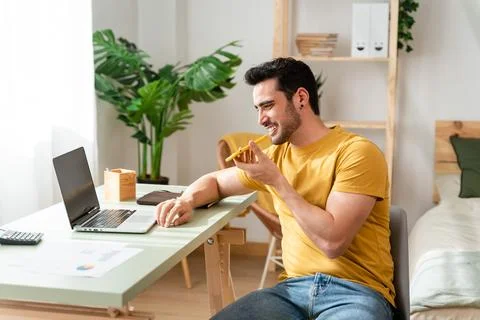 Remote worker sending voice note with cell phone. Stock Photos