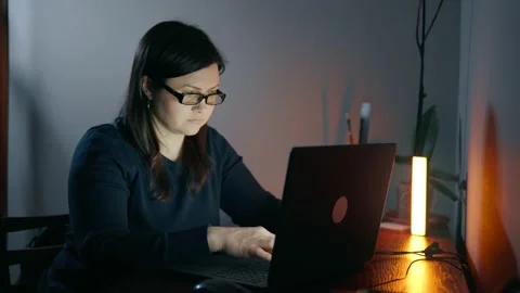 A remote worker is sitting at a laptop in a home office Stock Footage 238956117