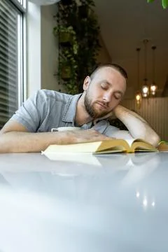 Remote worker studying at a table in a bright space with plants during the da Stock Photos