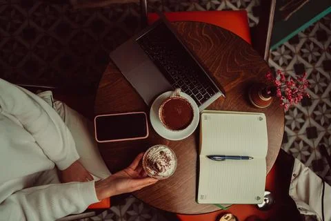 Remote worker using a laptop and phone in a cafe Foto stock