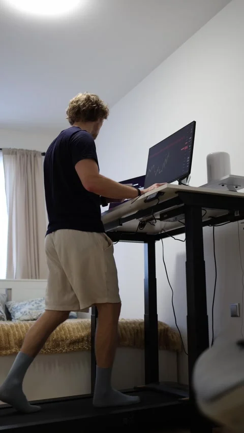 Remote worker walks on treadmill while working from home at computer Stock Footage 346881018