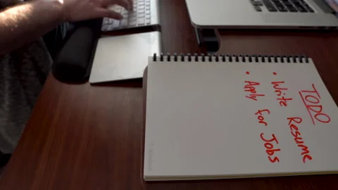 Remote Worker Writes Resume After Being Laid off or Furloughed During Pandemic 動画素材 144837298